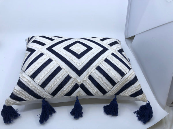 DARK BLUE AND WHITE DIAMOND PATTERN PILLOW WITH TASSELS.