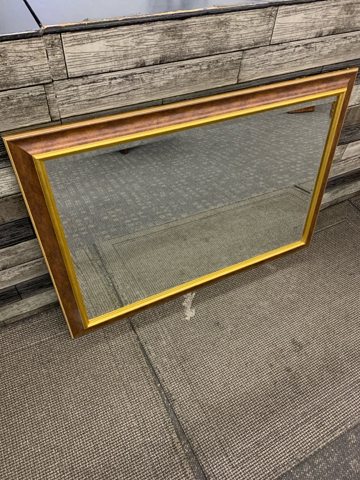 HEAVY MIRROR WITH GOLD RIMMED FRAME.