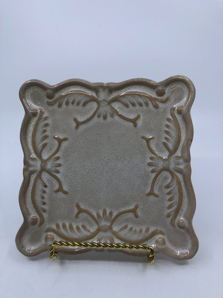 TAN AND WHITE SQUARE CANDLE PLATE.