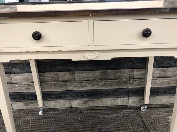 ANTIQUE DARK WOOD AND CREAM DESK ON WHEELS WITH 2 DRAWERS.