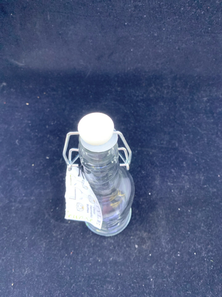 GLASS BOTTLE WITH WHITE FLIP TOP.