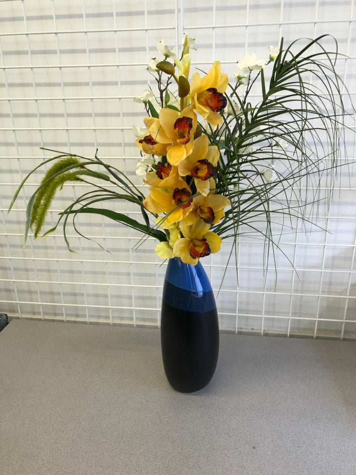 BLUE AND BLACK VASE WITH YELLOW AND WHITE FLOWERS.
